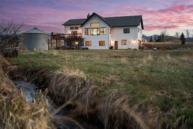 rear view of property with a trampoline and a chimney