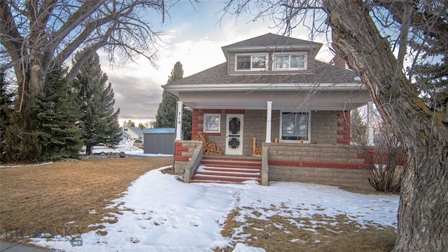 view of front of house featuring a porch and a storage unit