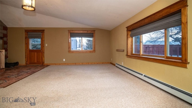 entryway with lofted ceiling, a baseboard radiator, a healthy amount of sunlight, and carpet flooring