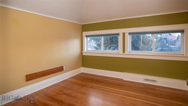 unfurnished room featuring crown molding and hardwood / wood-style floors