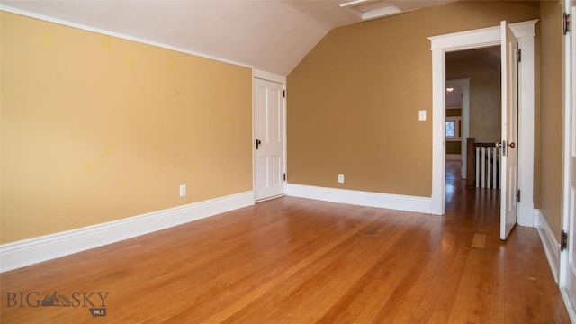 additional living space with wood-type flooring and vaulted ceiling