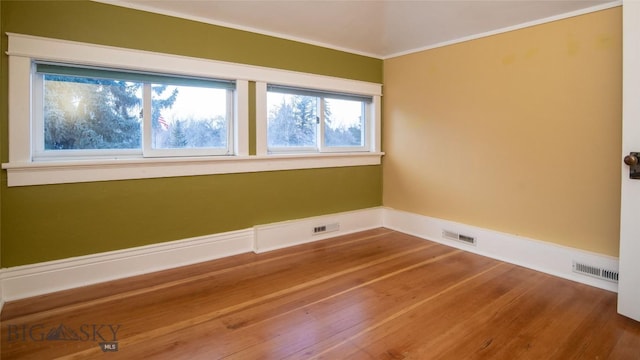 unfurnished room with crown molding and hardwood / wood-style floors