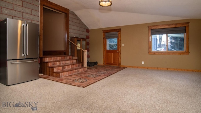 carpeted entryway featuring vaulted ceiling