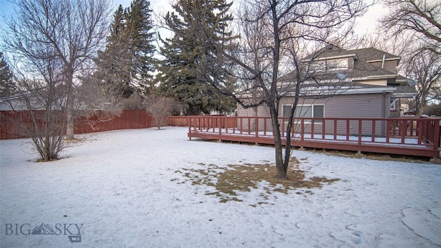 snowy yard with a wooden deck