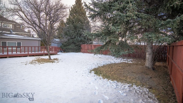 yard covered in snow with a deck