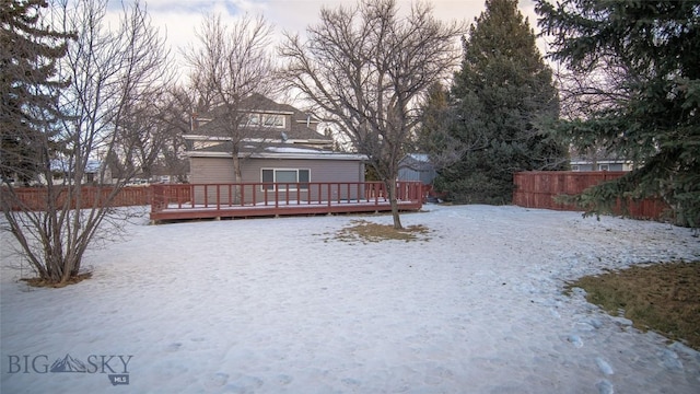 yard covered in snow featuring a deck