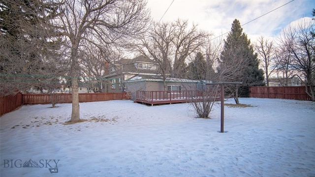 yard layered in snow featuring a wooden deck