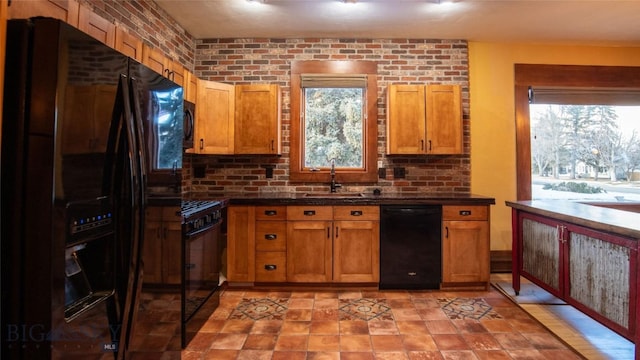 kitchen featuring brick wall, sink, and black appliances