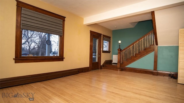 empty room featuring a baseboard radiator, radiator, and light wood-type flooring