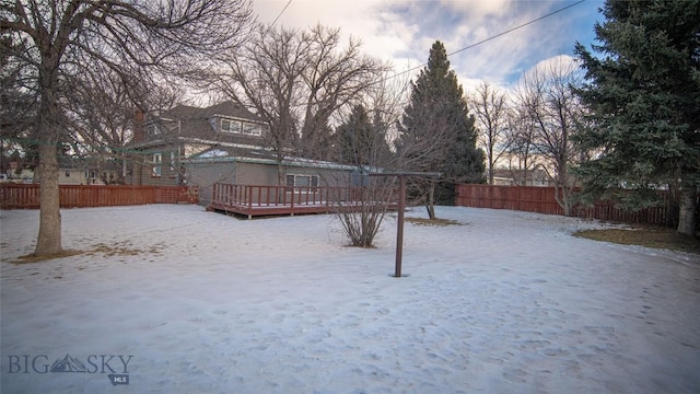 yard covered in snow with a wooden deck