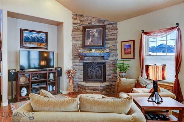 living room with lofted ceiling, a fireplace, baseboards, and wood finished floors