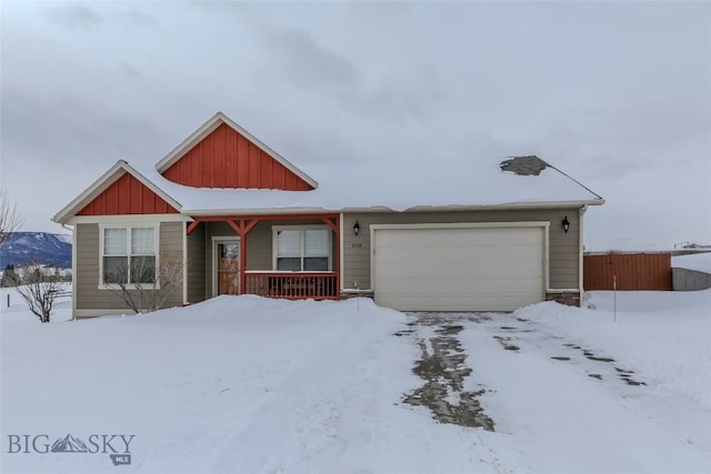 view of front of home with board and batten siding, fence, and an attached garage