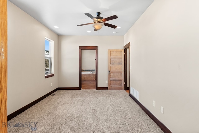 unfurnished bedroom featuring ensuite bathroom, carpet floors, and ceiling fan