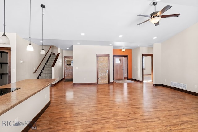 unfurnished living room with light hardwood / wood-style flooring and ceiling fan