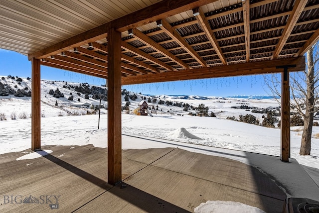 snow covered patio featuring a mountain view