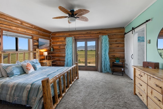 bedroom with a barn door, carpet floors, access to outside, and log walls