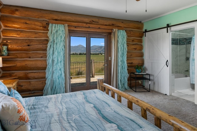 bedroom featuring connected bathroom, carpet flooring, access to outside, a mountain view, and a barn door