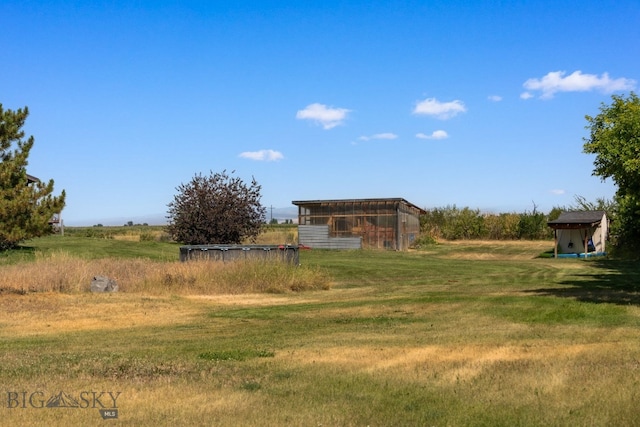 view of yard with an outbuilding and a rural view