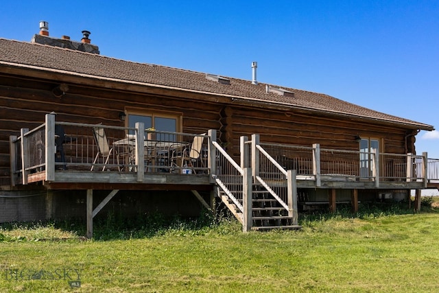 rear view of house with french doors, a deck, and a lawn