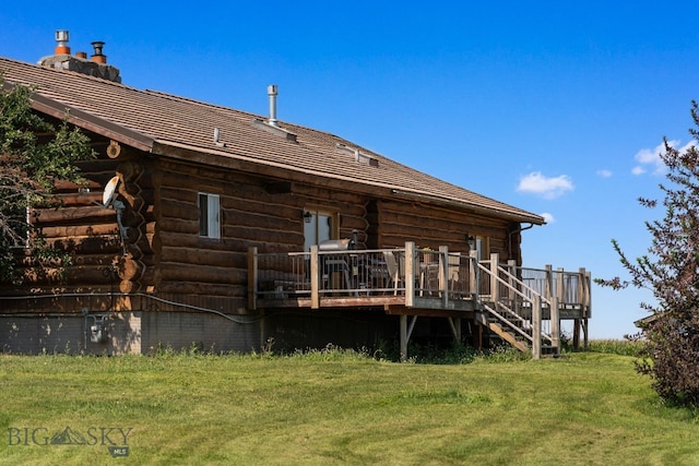 rear view of property featuring a wooden deck and a lawn