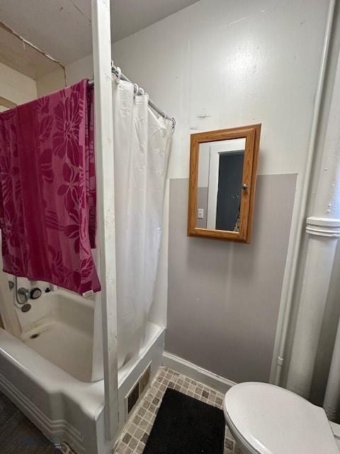 bathroom with shower / bath combo and toilet