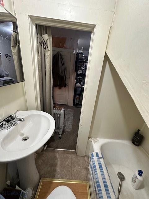 bathroom with radiator, tile patterned floors, sink, and toilet