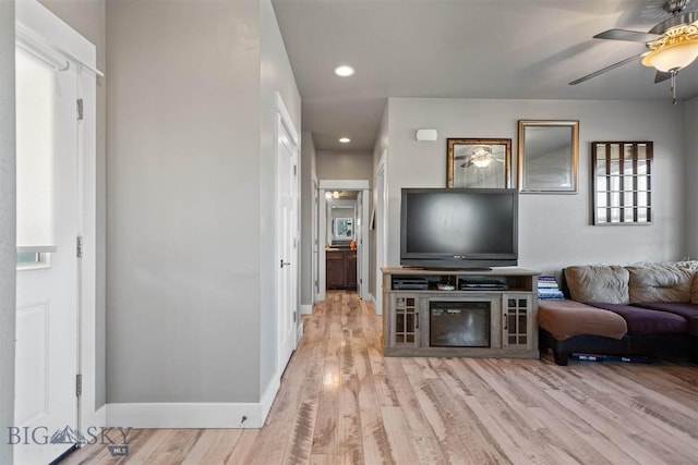 living room featuring ceiling fan and light wood-type flooring