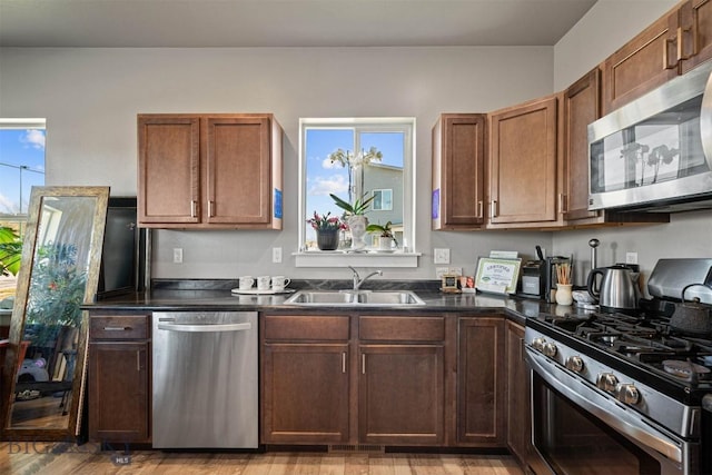 kitchen featuring sink, a wealth of natural light, light hardwood / wood-style floors, and appliances with stainless steel finishes