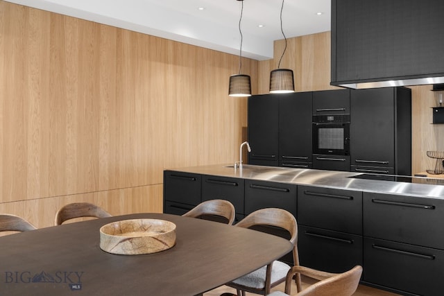 217 W Beall St Unit B, Bozeman, MT 59715 - kitchen featuring stainless steel countertops, black oven, modern cabinets, dark cabinetry, and hanging light fixtures