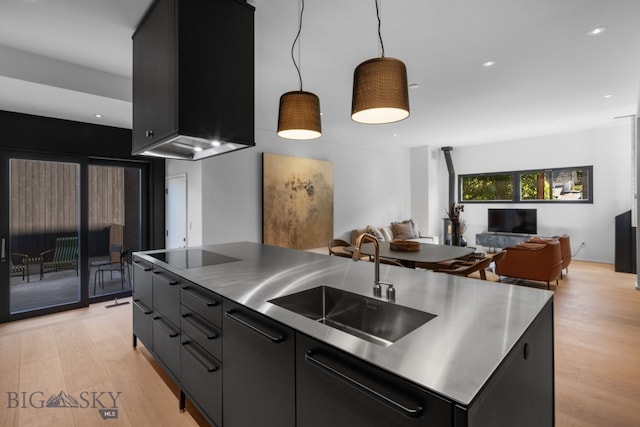 217 W Beall St Unit B, Bozeman, MT 59715 - kitchen with stainless steel countertops, black electric cooktop, open floor plan, dark cabinetry, and light wood-type flooring