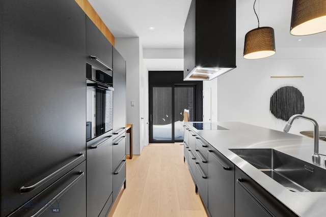 217 W Beall St Unit B, Bozeman, MT 59715 - kitchen featuring wall chimney exhaust hood, decorative light fixtures, light wood-type flooring, oven, and stovetop