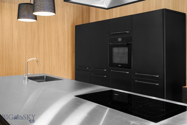 217 W Beall St Unit B, Bozeman, MT 59715 - kitchen with stainless steel counters, black appliances, dark cabinets, modern cabinets, and pendant lighting