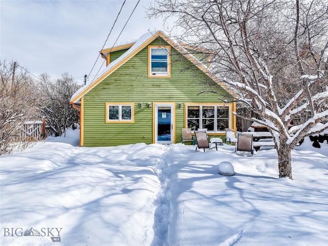 view of snow covered rear of property