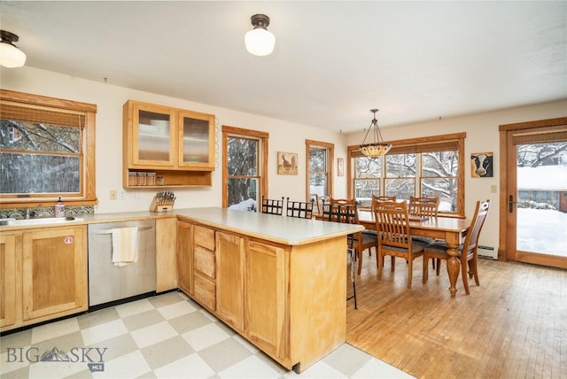 kitchen with pendant lighting, dishwasher, a baseboard radiator, sink, and kitchen peninsula