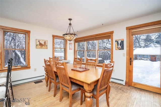 dining room featuring a baseboard radiator, a healthy amount of sunlight, and light hardwood / wood-style floors