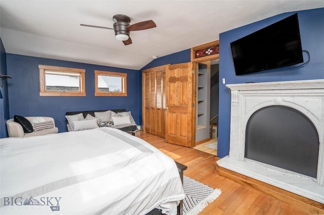 bedroom with ceiling fan, lofted ceiling, and light wood-type flooring