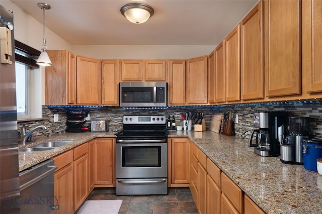 kitchen with tasteful backsplash, appliances with stainless steel finishes, decorative light fixtures, light stone countertops, and a sink