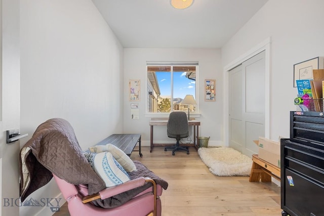 home office with light hardwood / wood-style flooring