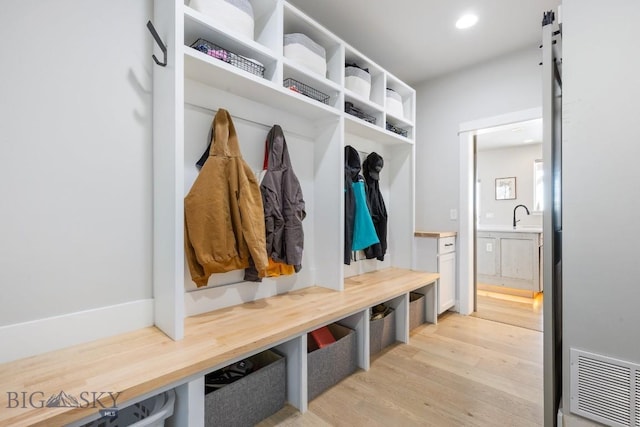 mudroom featuring sink and light hardwood / wood-style floors