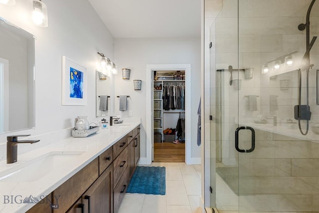 bathroom with vanity, a shower with shower door, and tile patterned floors