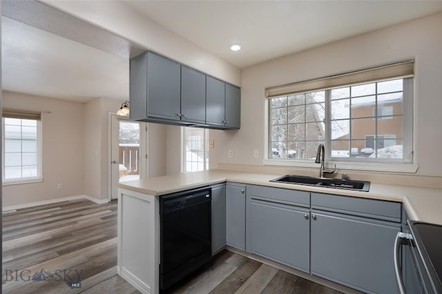 kitchen featuring sink, hardwood / wood-style flooring, range, black dishwasher, and kitchen peninsula