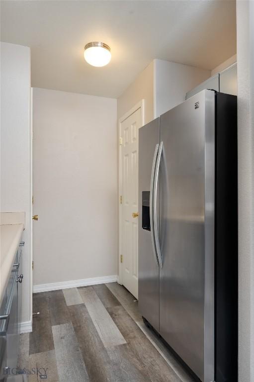 kitchen with stainless steel fridge and dark hardwood / wood-style flooring