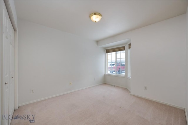 spare room featuring light colored carpet