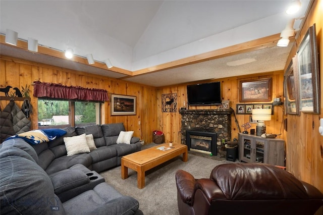 carpeted living room featuring vaulted ceiling, wooden walls, and a fireplace