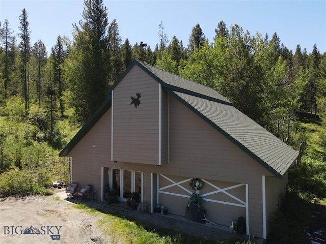770 Mountain Moose Rd, Bozeman, MT 59715 - view of side of home featuring a barn, a wooded view, and an outdoor structure