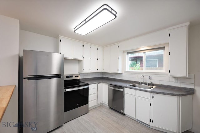 kitchen featuring sink, stainless steel appliances, white cabinets, and light wood-type flooring