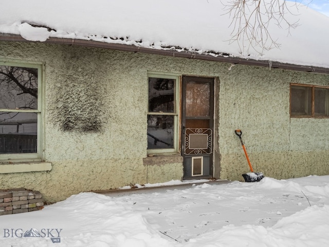 snow covered property entrance with cooling unit