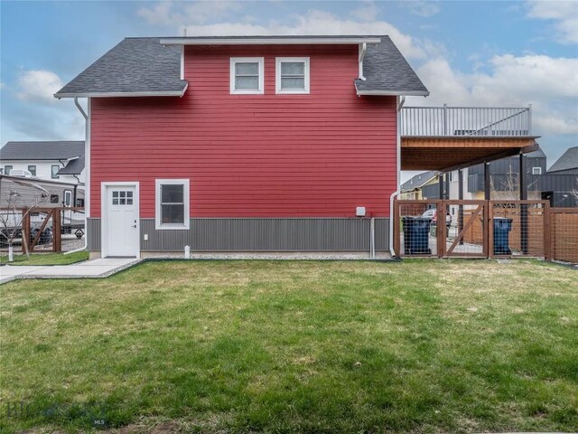 4562 Bembrick St, Bozeman, MT 59718 - view of side of home featuring fence, a yard, a shingled roof, and a deck