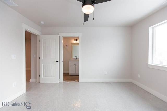 unfurnished bedroom featuring ensuite bath and ceiling fan