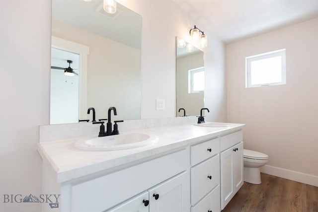 bathroom featuring hardwood / wood-style flooring, vanity, ceiling fan, and toilet